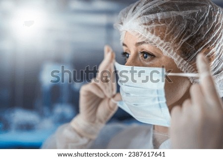 young female nurse putting her medical mask at surgery. Healthcare worker