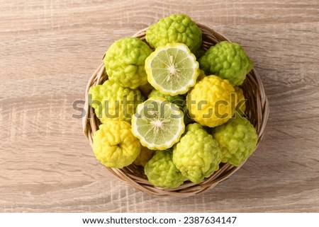 Kaffir lime fruit in basket on wooden background, Organic ingredients in Thai cuisine, beauty and cosmetics