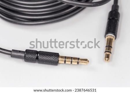 Gold colored stereo connectors mini jack on the edges of analog audio cable on a gray surface, close-up in selective focus
 Royalty-Free Stock Photo #2387646531