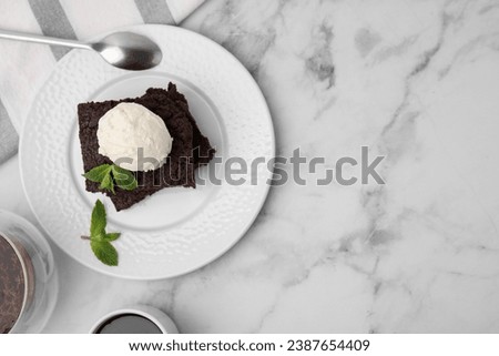 Tasty brownies with ice cream and mint served on white marble table, flat lay. Space for text