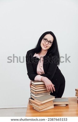 woman with a stack of books in the library training science education