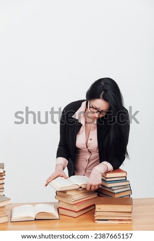 woman with a stack of books in the library training science education