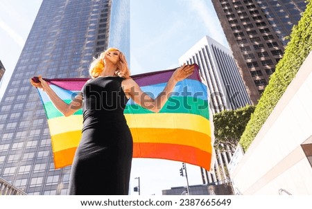 Transgender business woman lifestyle moments in downtown, Los angeles. Transgender woman holding a rainbow  flag and standing for the lgbt community rights at a public manifestation
