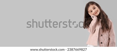 Little girl in stylish clothes on grey background with space for text