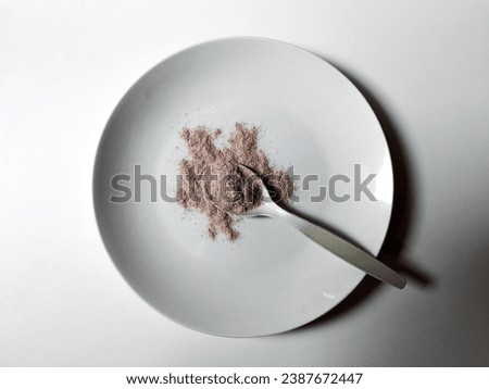 close up Pile of fresh ground coffee latte and spoonful of coffee latte powder on a white plate isolated on white background.  top view