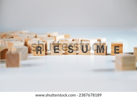 Letters RESUME written on wooden cubes, many blurred blank cubes around as a symbol for other candidates, application concept for the business career, gray background, copy space, selected focus