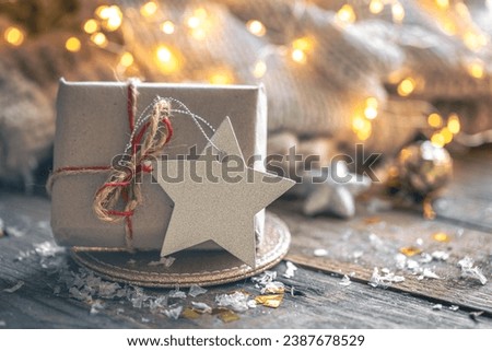 Cozy composition with a Christmas gift box on a blurred background. Royalty-Free Stock Photo #2387678529