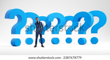 Pensive african businessman with blue question marks set in row on white background. Concept of solution, problem, search, career, business or start up Royalty-Free Stock Photo #2387678779