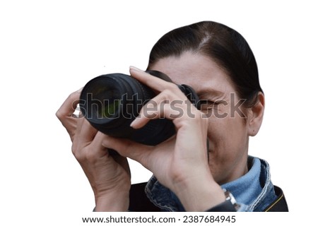 Professional photographer - woman in the process of shooting. Portrait of a Caucasian brunette woman in a denim jacket holding a camera, isolated on a white background.