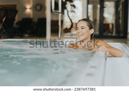 Pretty young woman relaxing in the indoor bubble pool Royalty-Free Stock Photo #2387697381