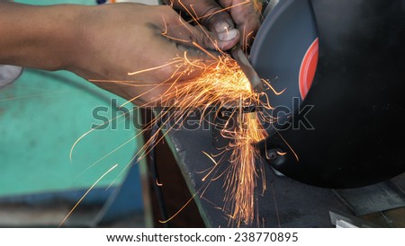 Close up shot of sparks from grinding wheel.metalworking industry: finishing metal working on horizontal surface grinder machine with flying sparks