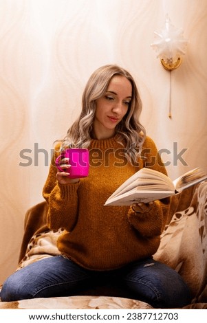 Woman at home on the couch reading a book. Home office. Remote Learning. High quality photo