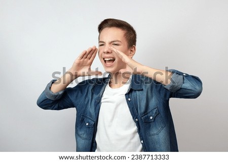Portrait of teenage boy calling someone, yelling announcement, white background