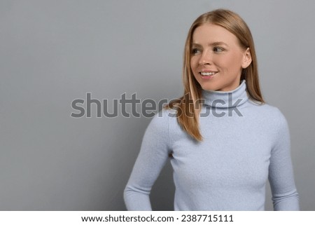 Portrait of beautiful young woman on grey background. Space for text