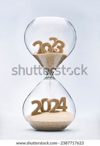 New Year 2024 concept with hourglass falling sand taking the shape of a 2024 Royalty-Free Stock Photo #2387717623