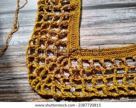 The process of crocheting from beads and sequins of golden color. Making a dress for a merry Christmas. High quality photo
