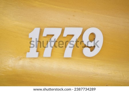 The golden yellow painted wood panel for the background, number 1779, is made from white painted wood.