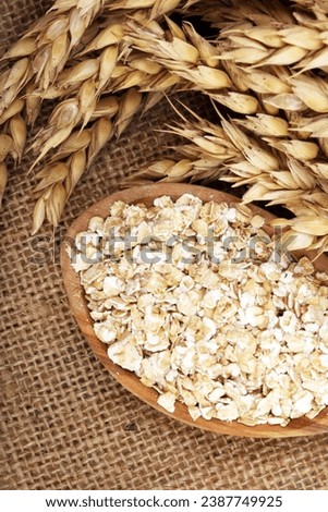 Oat flakes or rolled oats and golden ears of wheat. Healthy lifestyle, healthy eating, vegan diet concept Royalty-Free Stock Photo #2387749925