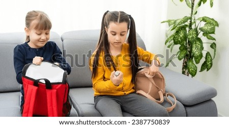Portrait of two little schoolgirls with backpacks