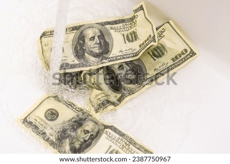 Money is thrown away in the sink. This photo concept illustrates the financial condition of a business that is failing or going bankrupt so that it only wastes money without results Royalty-Free Stock Photo #2387750967