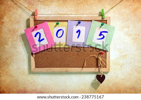 Vintage 2015 write on paper photo frame over wall background, New year concept