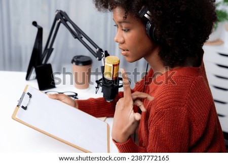 Host channel of beautiful African woman influencer talking with listeners in broadcast studio with script note. Time slot of life coach consultant on live social media online. Tastemaker.