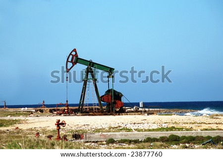 Oil pump jack in work on an ocean or sea coast