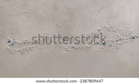 cream color wall background texture, with cracked bubbles forming an eye mask