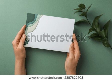 Woman holding blank invitation card on green background, top view. Space for text