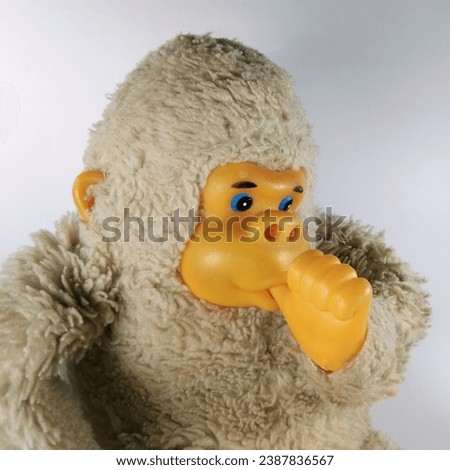 Baby monkey doll, sucking his own thumb in closeup 