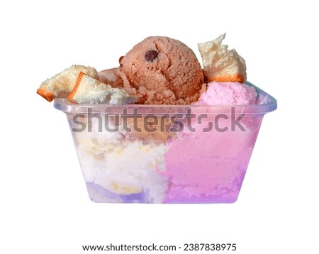 Es Puter Indonesia. Traditional coconut milk ice cream sundae with vanilla, chocolate and strawberry flavor topped with bread slices in clear plastic container isolated on white background.