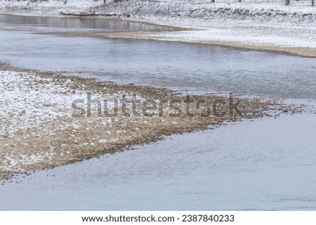 Nature landscape of a sharp acute angle of a gravel sandbar in the middle of a flowing river. Royalty-Free Stock Photo #2387840233