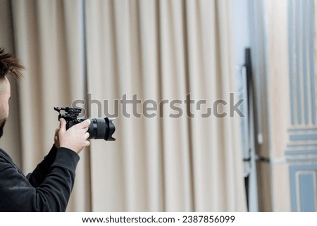 A cameraman broadcasts from the event, a guy shoots a photo report. A man with a camera in his hands. High quality photo