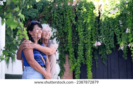 Friendship concept. Two mature senior women hugging with tenderness in outdoors enjoying togetherness