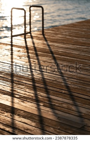 Defocused image of a pontoon, stairs in the swimming pool at beach or the resort. The dreaming of a summer vacation at sea. Minimalism style.
 Royalty-Free Stock Photo #2387878335