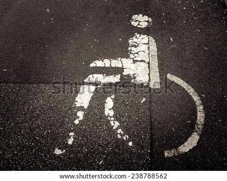 handicapped parking sign painted on asphalt