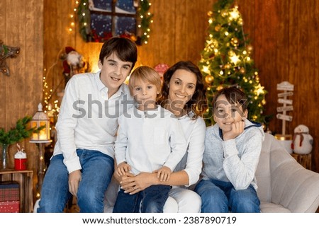 Happy family, children and mom, taking family pictures in a cozy christmas studio together