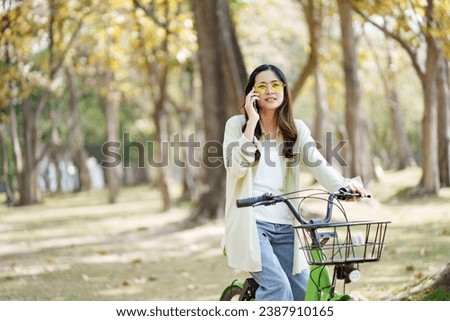 Healthy wellbeing lifestyle, Young asian female riding bicycle at public park
