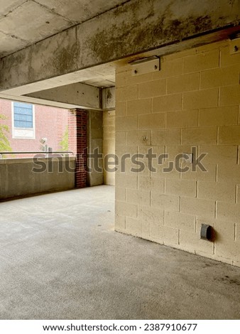 View past a corner of concrete wall in parking garage