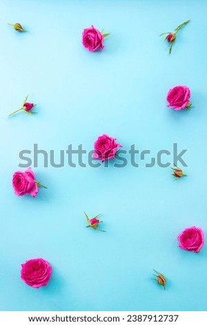 Pink flowers and buds on blue background. Vertical floral pattern. Selective focus