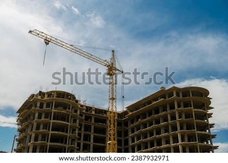 Construction of a multi-storey residential building in a new area with a crane. Horizontal photo