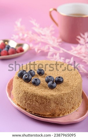 Napoleon cake on pink background.  A whole honey cake.
