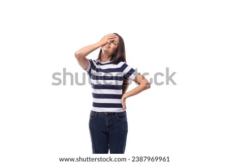 cute young european woman with black straight hair wears striped black and white t-shirt and jeans in summer. people clothes concept