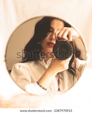 young pretty woman taking photo of herself in the mirror