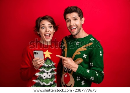 Photo of amazed family lady guy holding cell smart gadget pointing web christmas offer isolated vivid color background