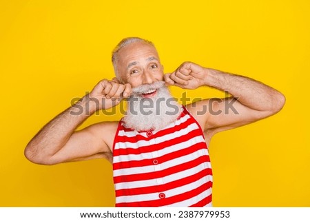 Photo of positive excited elderly guy dressed striped red swimsuit adjusting hands arms mustaches isolated yellow color background