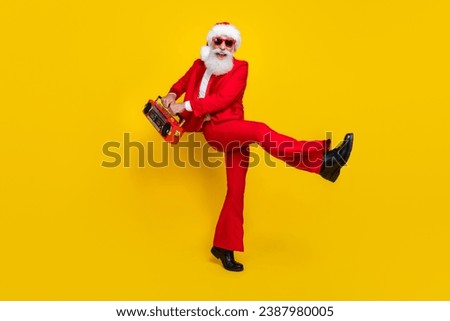 Full size portrait of positive funky man dancing hands hold boombox isolated on yellow color background