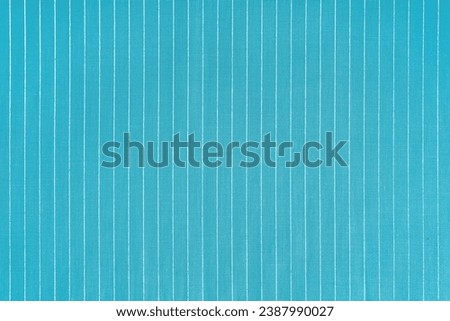 Striped turquoise white fabric texture background wtih copy space. Shirt fabric, tablecloth textile, garment cloth, upholstery with classic pattern with lines. Backdrop, wallpaper, background. Royalty-Free Stock Photo #2387990027
