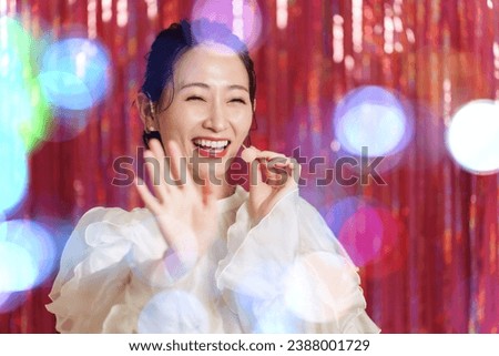 attractive asian idol singing on stage with headset  Royalty-Free Stock Photo #2388001729