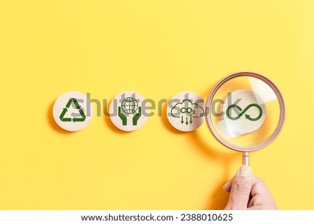 Magnifying glass focus circle wooden block with Infinity symbol for circular economy to reduce waste by reusing, Reduce pollution for future business and environmental growth.